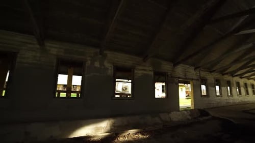 Interior pan from right to left of an abandonded barn near an insane asylum, dark, creepy, condemned