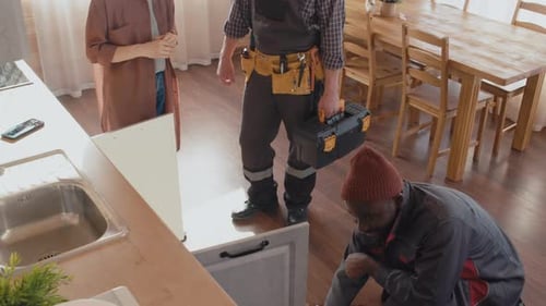 Woman Discussing Breakage with Repairmen