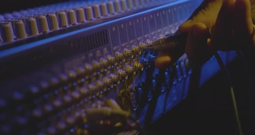 A technician works with a Mixing console
