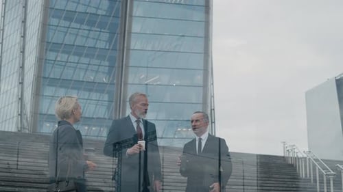 Businesspeople Having Conversation with Coffee outside Modern Skyscraper in City