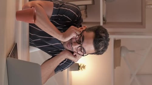 Man with Laptop Leans on Hands at Desk