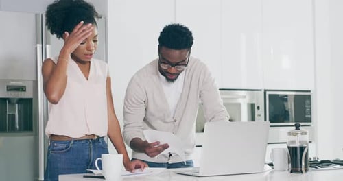 Couple Reviews Documents Together in Modern Kitchen