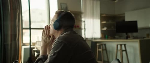 Man with Headphones Listening Indoors in Modern Apartment