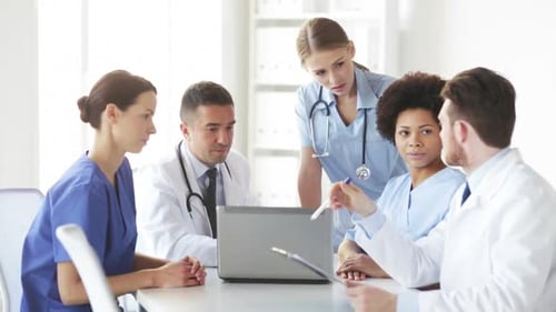 Doctors meeting at hospital discussing patient care using technology
