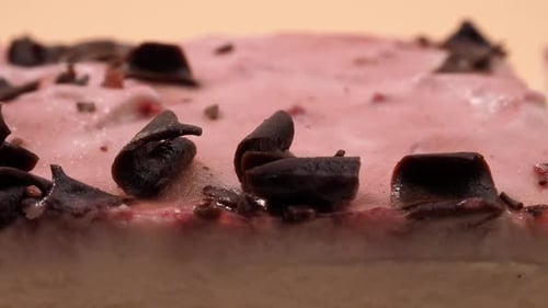 Delicious Sliced Cake with Pink Frosting and Chocolate