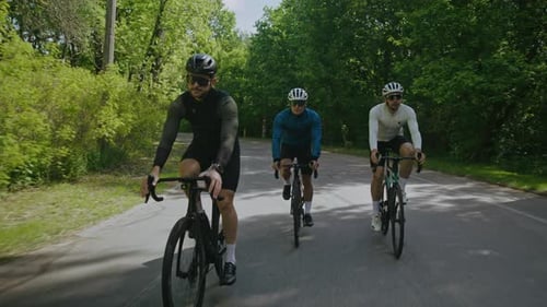 Radfahrer mit Schutzhelmen und Schutzbrillen fahren Fahrrad auf der Landstraße