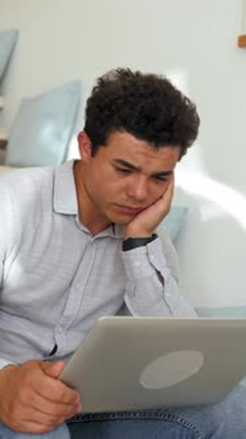 Vertical of Sleepy Man Looks at Screen of Laptop Listening to Lesson