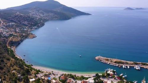 Drohnenansicht einer Küstenstadt mit grünen Bergen