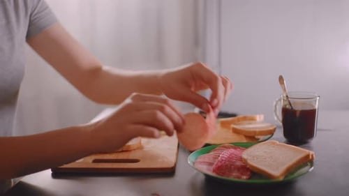 Woman Making Sandwich at Table in Kitchen
