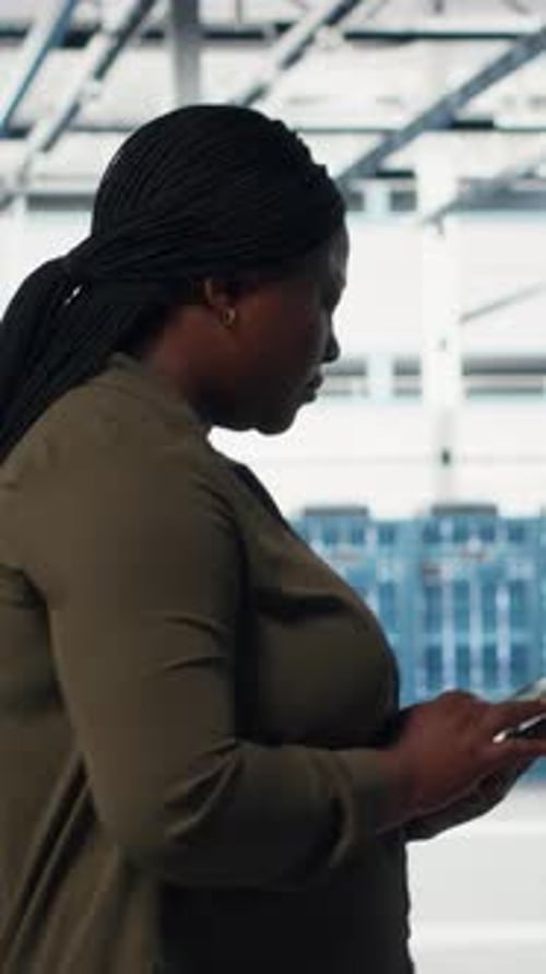 Vertical Video Smiling Engineer Walking in Data Center with Laptop Checking Hardware