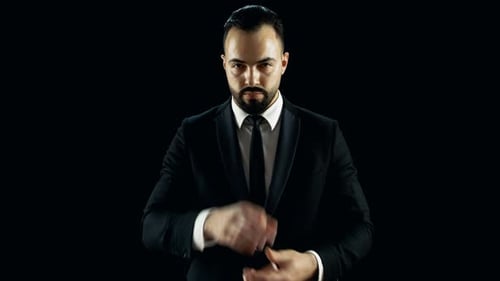 Magician performing card tricks against black background