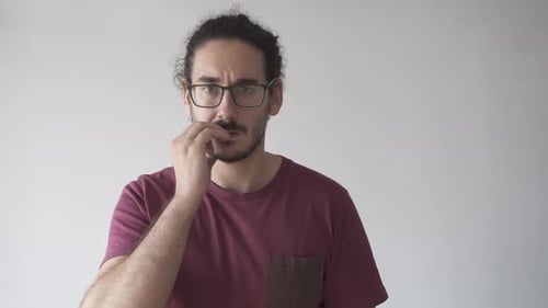 Young Adult Picking at Facial Hair Indoors