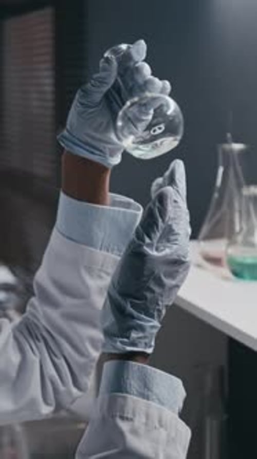 Close Up of Flask Held by Gloved Hands