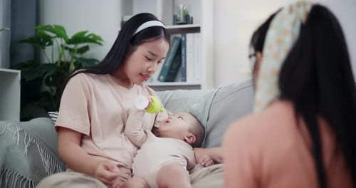 Mother Interacts With Baby at Home on Couch