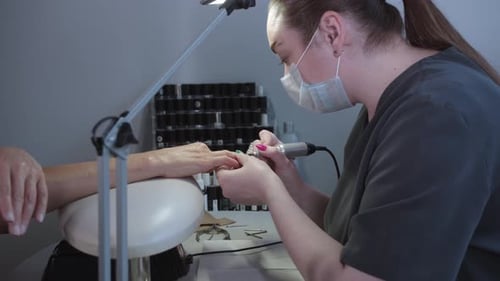 Manicurist Filing Nails at Beauty Salon