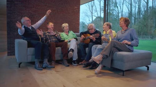 Adults Singing and Playing Guitar Together on Couch