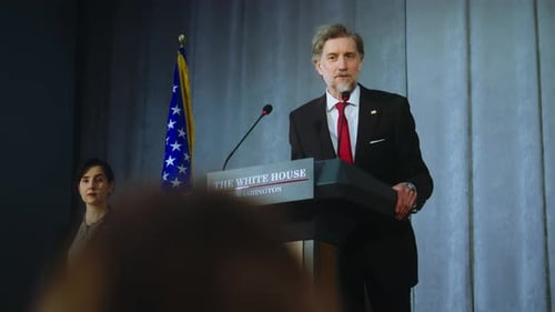 Man Delivering Speech at Podium with American Flag