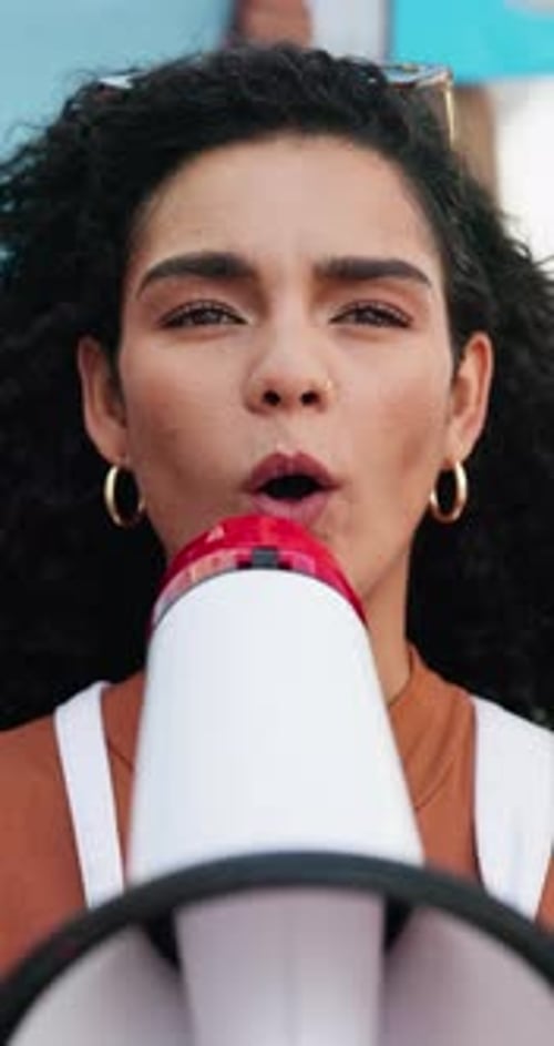 Young Adult Speaks into Megaphone at Rally