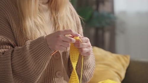 Woman Crocheting with Yellow Yarn in Relaxing Setting