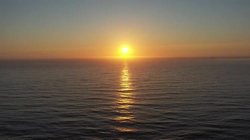 Drone shot of sunset over the ocean fading back towards the beach.
30 seconds