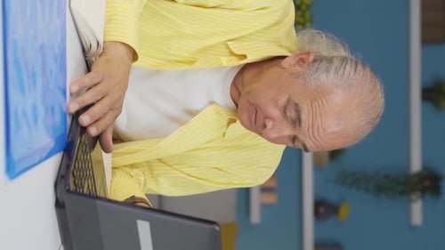 Vertical video of Home office worker old man stressed and thoughtful.