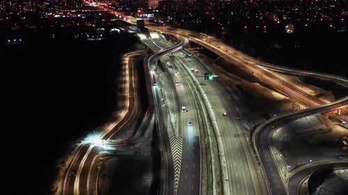 Aerial flyover traffic jam interchange road at night, drone shot top down view roadway intersection