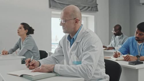 Medical Professionals Taking Notes in Classroom Setting