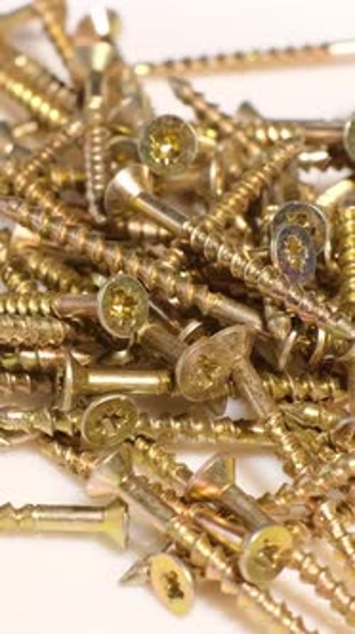 Yellow Metal Screws Rotate in a Circle Fasteners When Working with Wood and Plasterboard Vertical