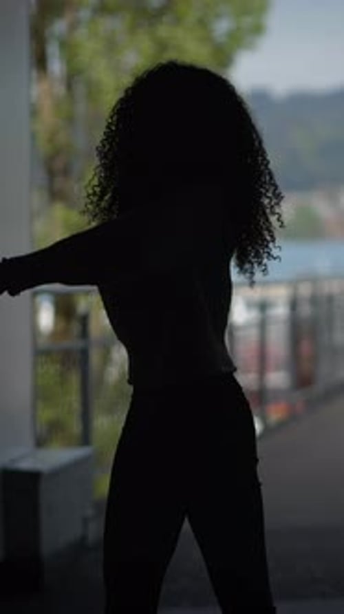 Silhouette of Woman with Curly Hair Dancing Urban