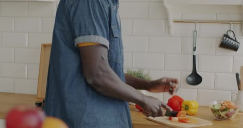 Man in Headphones Prepares Vegetables in Kitchen
