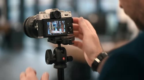 Professional photographer shooting a business meeting in an office using a camera on a tripod