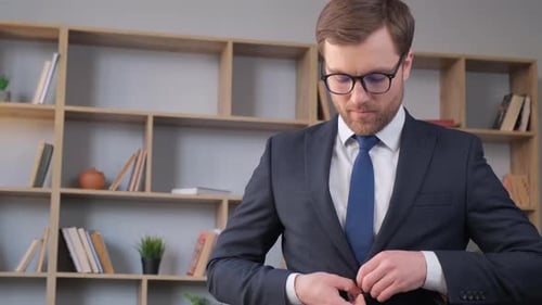 Man in Suit Buttons Jacket in Office