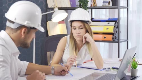 Zwei Architekten sprechen im Architekturbüro über ein Zeichenprojekt.