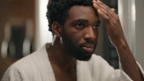 Man Grooming Facial Skin in Mirror at Home