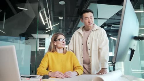 Team Discussing Data on Computer in Modern Office