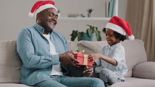 Man and Child Exchanging Christmas Gift on Couch