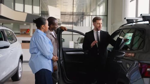 Salesman Explains Car Features to Couple in Dealership