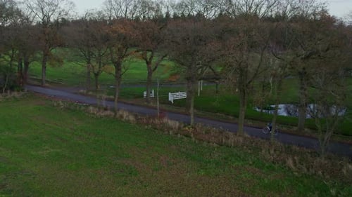 Aerial view of village with woman cycling at sunset, Netherlands.