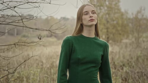 Model posing wearing green dress in autumn nature