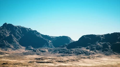 Expansive Sunlit Desert with Tall Black Ridges and Sandy Plains