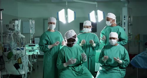 Portrait of diverse surgeons wearing surgical gowns in operating theatre, slow motion