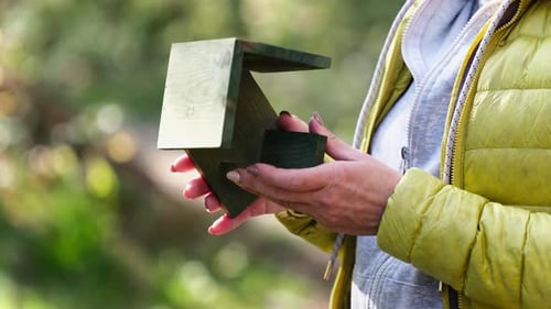 Mangeoire à oiseaux en bois pour fille tenant dans ses mains