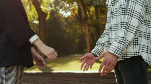 Side View Closeup of Unrecognizable Young Couple in Love Taking Each Other Hands Outdoors on