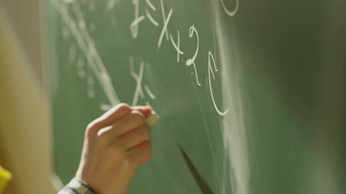 A Girl Student Writes on a Green Board
