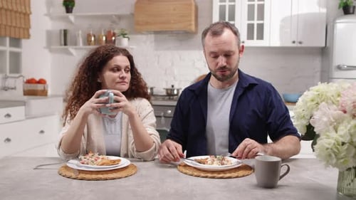 Couple Eating Breakfast Together at Kitchen Table