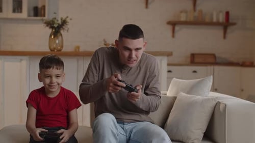 Boy and Young Adult Play Video Games at Home
