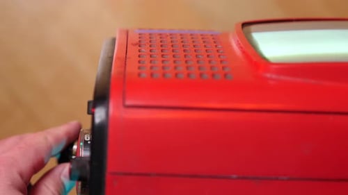Hand Tuning Old Red Portable Television Set Hand Turning the Channel Knob Portable Television Set