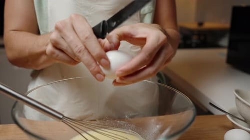 Person Cracking Egg into a Glass Bowl, Preparing Ingredients for Baking, Creating a Kitchen Cooking