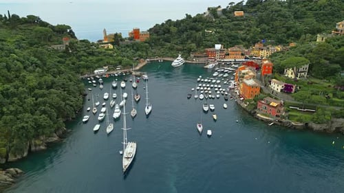 Portofino, renowned coastal town in Liguria, Italy, features its iconic harbor filled with yachts an
