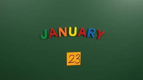 Hand sticking a sticker 23 January calendar day on school board. 23 date of January. Twenty third